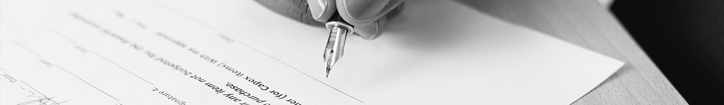 Fotografia de uma mão assinando um contrato com uma caneta - Unijorge